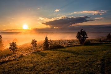 sunset over grassy hills