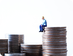 Toy person sitting atop stack of US quarters