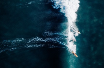bird's eye view of surfers on big wave