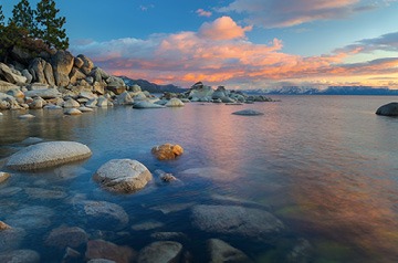 Pink sunset clouds over a mountain lake.
