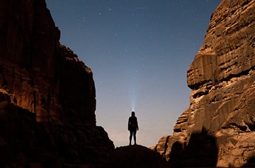 looking at night sky between desert plateaus