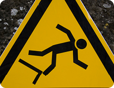 yellow triangle warning sign showing outline of person falling off ledge