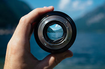 looking at landscape through detached camera lens