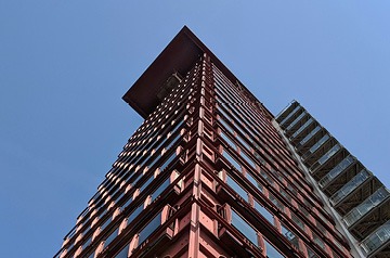 Looking skyward along glass-sided building