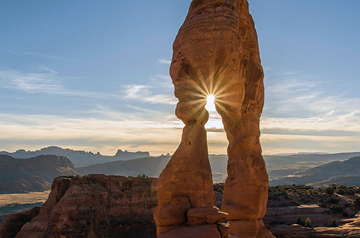 sunlight through arch of red rocks